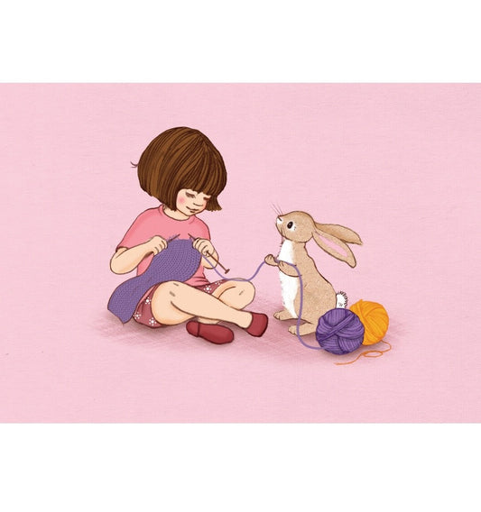 Kind sitzt auf dem Boden und strickt mit einem Kaninchen, das an einem Wollknäuel zieht.