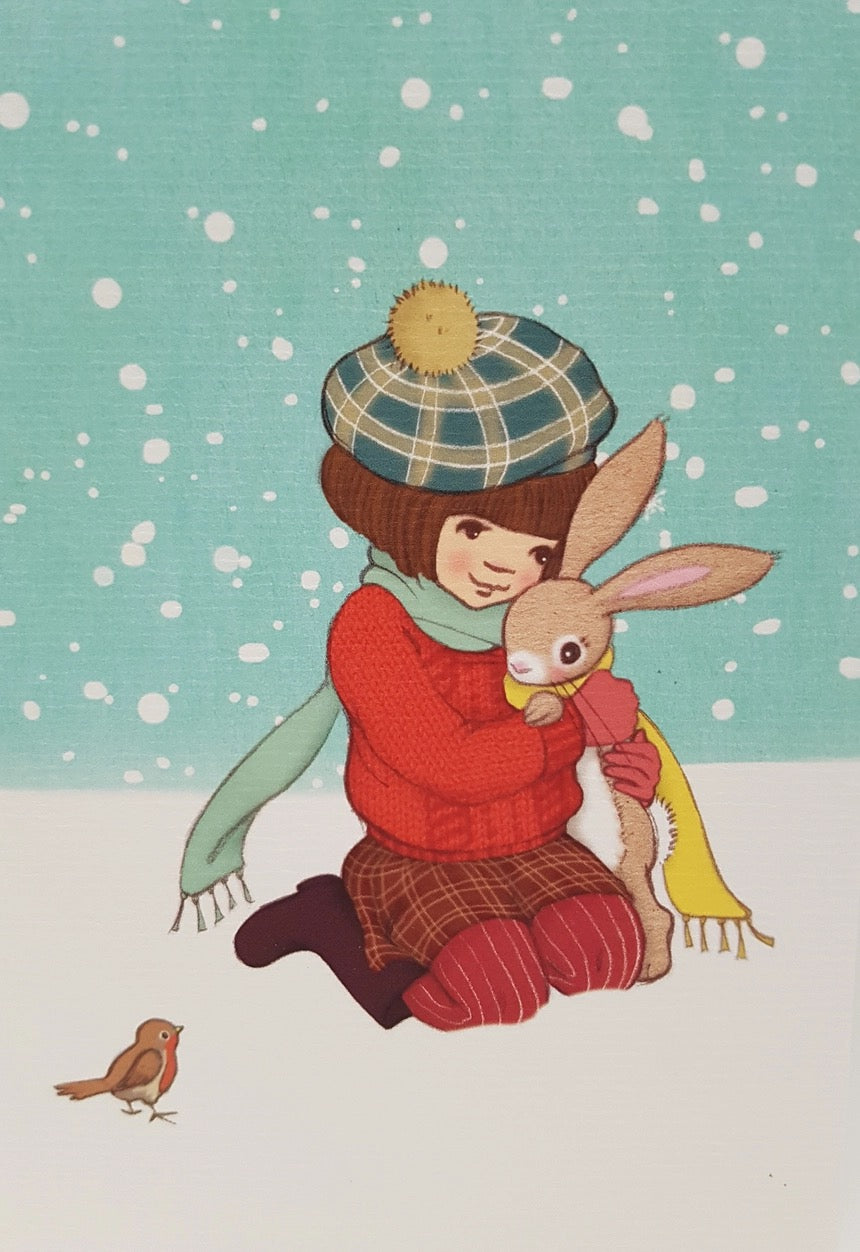 Ein Mädchen mit kariertem Mütze und grünem Schal kniet im Schnee und umarmt einen Hasen mit gelbem Schal, während Schneeflocken fallen und ein kleiner Vogel daneben steht.