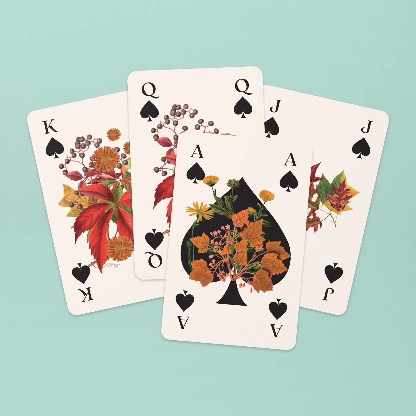 Vier Spielkarten der Pik-Familie sind fächerförmig auf mintgrünem Grund arrangiert. Das Pik-As liegt im Vordergrund und zeigt ein großes, schwarzes Pik-Symbol, das kunstvoll mit gelben Blüten und herbstlichen Blättern verziert ist. Dahinter sind König, Dame und Bube gefächert, die allesamt mit detailreichen, rot-braunen Blättern, Beeren und Zweigen illustriert sind.