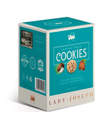 Dreidimensionale Ansicht einer rechteckigen Keksschachtel von „Lady Joseph“. Die Vorderseite ist in Türkisblau gehalten mit cremeweißem Rahmen. Der Aufdruck lautet „Artisan Vegan Cookies - Ceylan Coconut & Dark Chocolate“. Darunter befinden sich Illustrationen einer Kokosnuss, eines Kekses und einer Kakaofrucht. Auf der Seitenseite sind Gütesiegel, Barcode und Qualitätsversprechen abgebildet.