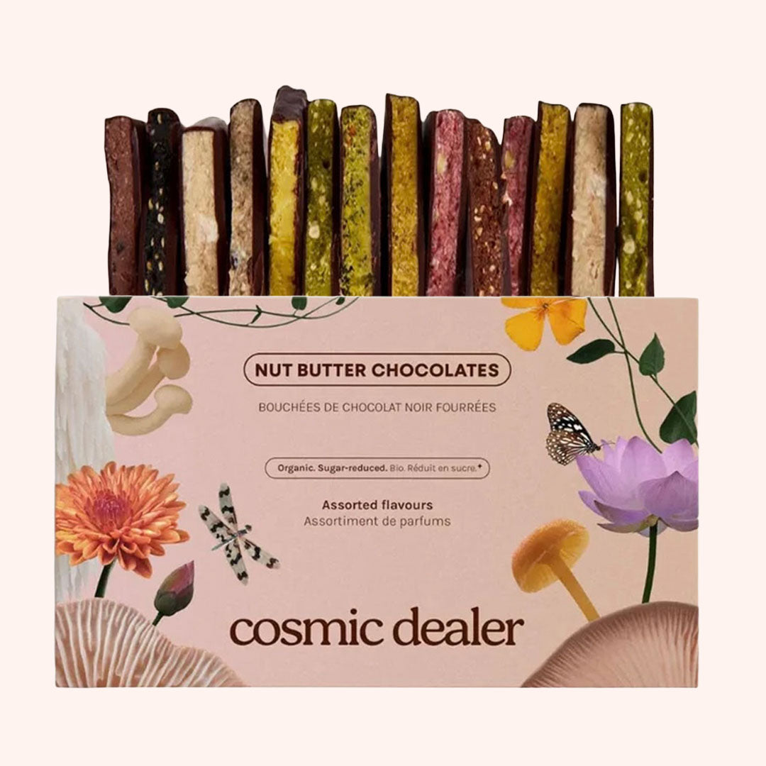 Draufsicht auf die Cosmic Dealer Nut Butter Chocolates Verpackung neben einem Stapel der aufgeschnittenen Nussmus-Schokoladenriegel.