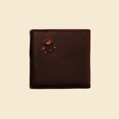 Draufsicht eines quadratischen Cosmic Dealer Schokoriegels mit Himbeerstückchen-Dekor.