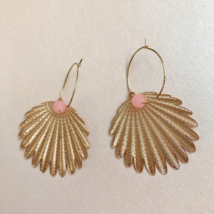 Goldfarbene Ohrringe in Federform mit feiner Struktur und rosafarbenem Perlenakzent an dünnem Bügel.