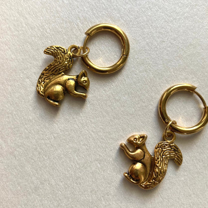 Goldfarbene Creolen mit Anhängern in Form von Eichhörnchen mit buschigem Schwanz.