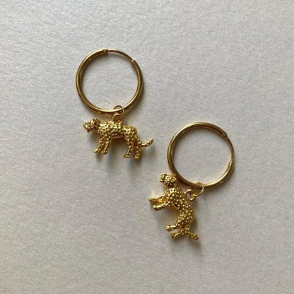 Goldfarbene Creolen mit kleinen, strukturierten Leopard-Anhängern in 3d-Optik.