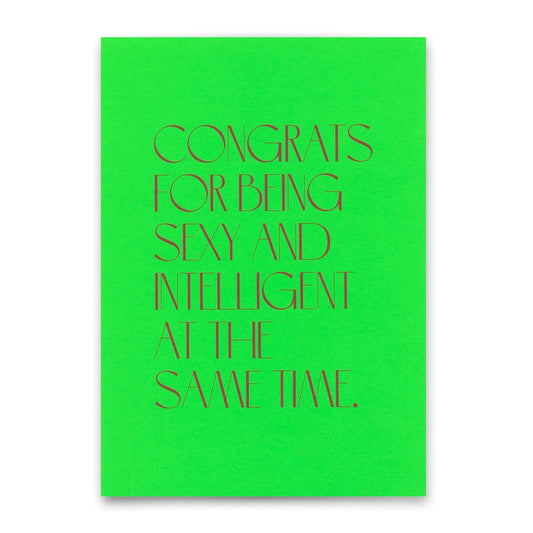 Eine neongrüne Postkarte mit feiner, dunkelroter Serifenschrift: „CONGRATS FOR BEING SEXY AND INTELLIGENT AT THE SAME TIME.