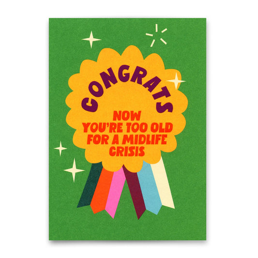 Grüne Geburtstagskarte mit einer gelben Ordensschleife und dem Text „CONGRATS NOW YOU'RE TOO OLD FOR A MIDLIFE CRISIS“.