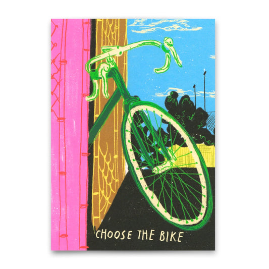 Ein grünes Fahrrad mit gebogenem Lenker steht schräg vor einer pinken Wand. Im Hintergrund sind ein blauer Himmel, schwarze Bäume und gelbe Zäune zu sehen. Unten im Bild steht in weißen Großbuchstaben der Schriftzug ‚CHOOSE THE BIKE‘.