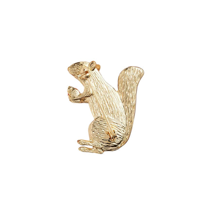 Goldfarbene Brosche in Form eines sitzenden Eichhörnchens mit detaillierter Struktur und Stiftverschluss auf der Rückseite.