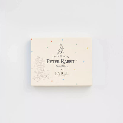 Schachtel mit Aufdruck 'The World of Peter Rabbit x Fable England' und Illustration eines Hasen sowie Blumenranken, umgeben von bunten Punkten.