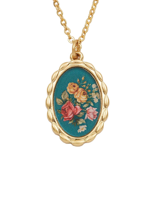 Goldfarbene Halskette mit ovalem Anhänger, der ein Blumenmuster auf blauem Hintergrund zeigt.