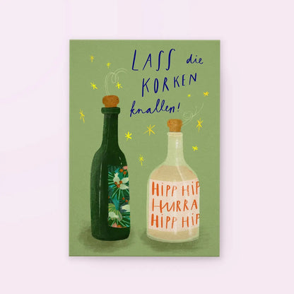 Zwei Flaschen mit Korken, eine grün mit Blumenmuster, eine weiß mit Text 'HIPP HIPP HURRA HIPP HIPP', darüber Schrift 'Lass die Korken knallen!'
