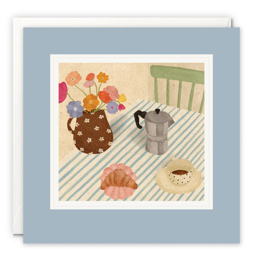 Illustration eines Frühstückstischs mit blau-weiß gestreifter Decke, Espressokocher, Kaffeetasse, Croissant und Blumenstrauß