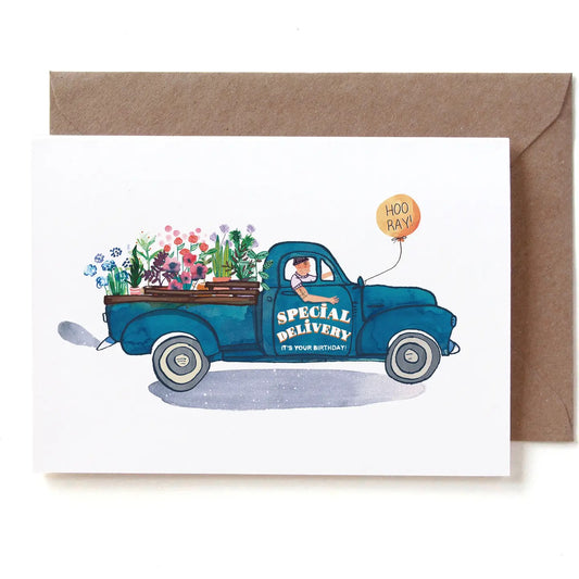Eine illustrierte Geburtstagskarte im Querformat, die einen nostalgischen, dunkelblauen Pickup-Truck im Profil zeigt. Auf der Fahrertür steht in geschwungener Schrift „SPECIAL DELIVERY - IT'S YOUR BIRTHDAY!“. Die Ladefläche ist voll beladen mit verschiedenen bunten Topfblumen und Pflanzen. Der tätowierte Fahrer blickt aus dem Fenster, während am Seitenspiegel ein orangefarbener Luftballon mit der Aufschrift „HOO RAY!“ fliegt. Die Karte liegt auf einem braunen Kraftpapier-Umschlag.