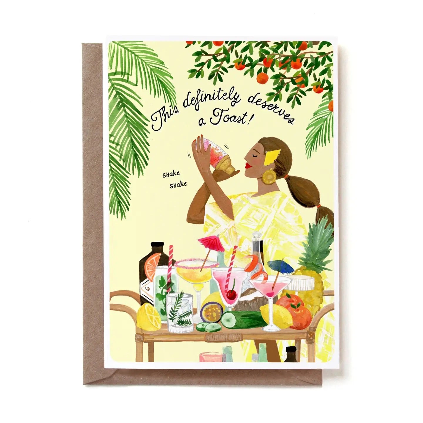 Eine illustrierte Glückwunschkarte mit der geschwungenen Aufschrift „This definitely deserves a Toast!“. Das Motiv zeigt eine Frau mit hochgesteckten Haaren und großen goldenen Ohrringen, die im Hintergrund schwungvoll einen Cocktail-Shaker bedient – untermalt von den kleinen Worten „shake shake“. Vor ihr auf einem hölzernen Servierwagen steht eine reichhaltige Auswahl an bunten Cocktails, frischen Zitrusfrüchten, einer Gurke und einer Ananas. Umrahmt wird die Szene von grünen Palmblättern und einem Orangen