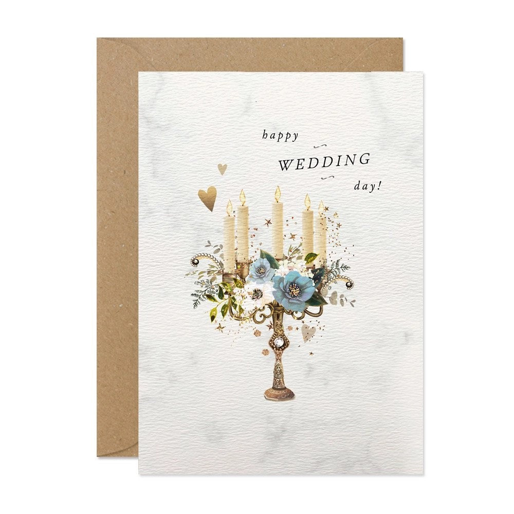 Karte mit einem goldfarbenen Kerzenhalter, vier brennenden Kerzen, blauen Blumen und dem Schriftzug 'happy WEDDING day!'.