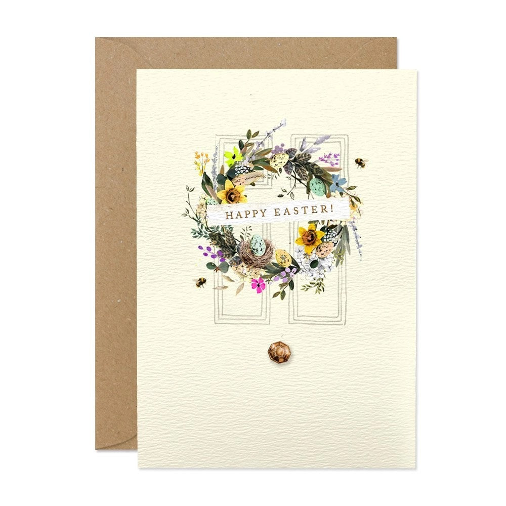 Cremefarbene Osterkarte mit einem detailreichen Kranz aus Blumen, Federn, Wachteleiern und Bienen, Text: "Happy Easter!".