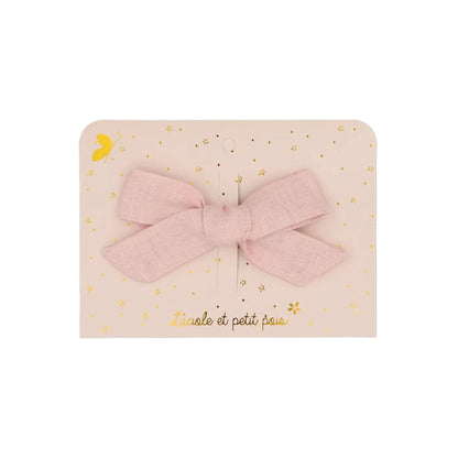 Zarte Haarschleife aus hellrosa Leinenstoff. Das minimalistische Design zeigt die natürliche Webstruktur des Materials, präsentiert auf einer hübschen Geschenkkarte.