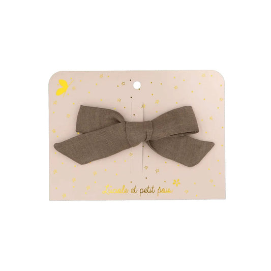 Klassische Haarschleife aus olivfarbenem Leinen. Die Schleife hat eine rustikale Textur und ist auf einer dekorativen Karte mit Golddetails fixiert.