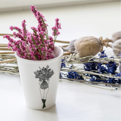 helen b Porzellanbecher verwendet als Vase mit rosa Trockenblumen auf weißem Holztisch