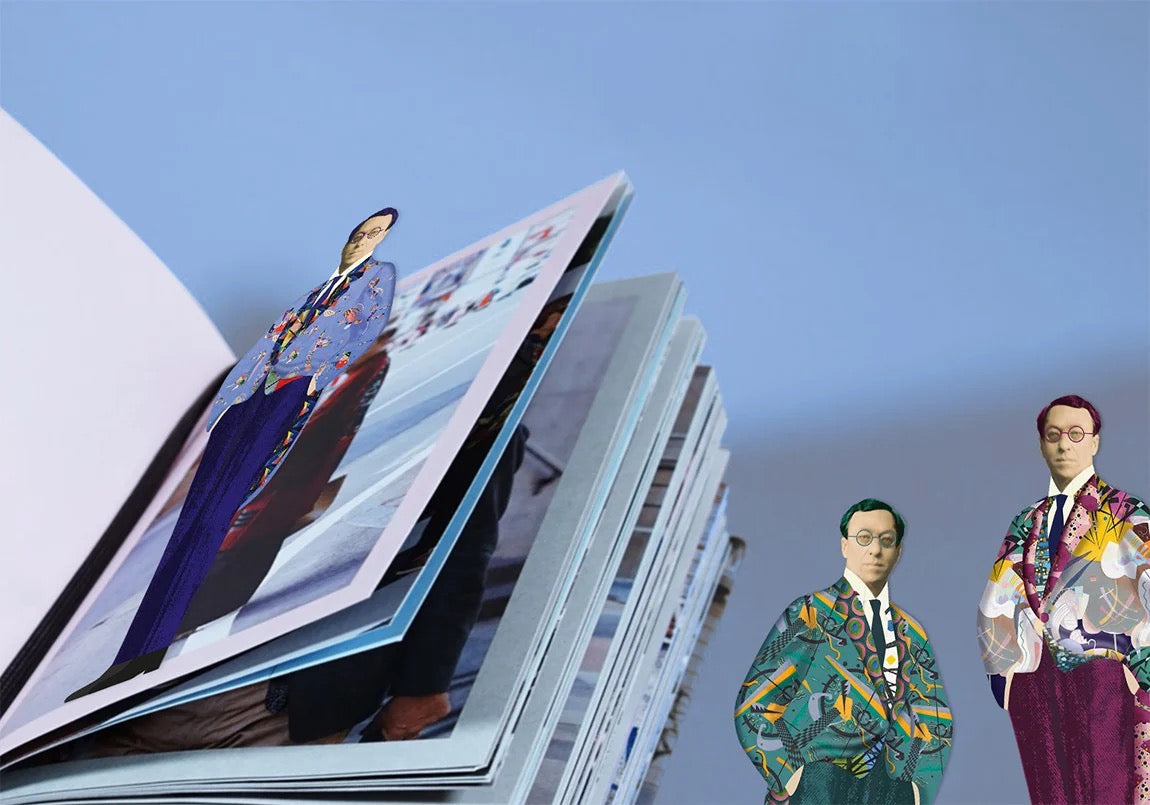 Ein aufgeschlagenes Buch liegt flach auf einem einfarbigen, hellblauen Hintergrund. Mittig in den Seiten steckt eines der figürlichen Kandinsky-Lesezeichen. Die Silhouette zeigt den Künstler in einer tiefblauen Hose und einem hellblauen Frack, der mit bunten, abstrakten Formen verziert ist, sodass der Oberkörper elegant über den oberen Buchrand herausragt.