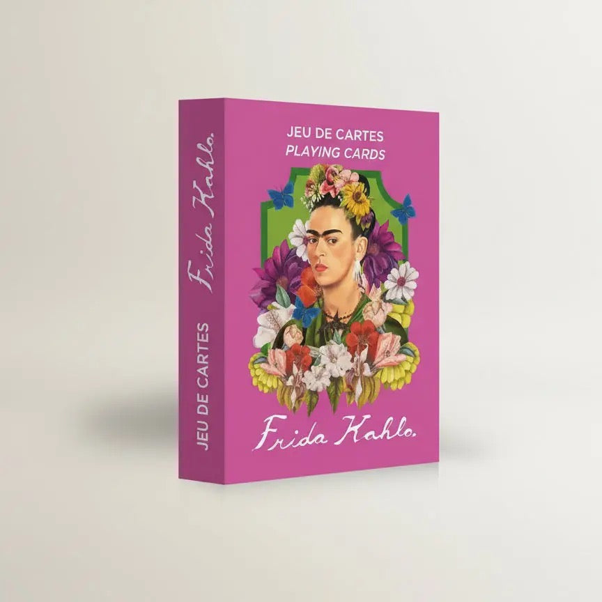 Eine geschlossene, hochkant stehende Produktbox des Frida Kahlo Kartenspiels von Mon Petit Art. Die Box ist in kräftigem Magenta gehalten. Auf der Vorderseite ist ein illustriertes Porträt von Frida Kahlo zu sehen, umrahmt von einem grünen Bogen, üppigen bunten Blumen und Schmetterlingen. Oben steht der Text „JEU DE CARTES / PLAYING CARDS“ und unten der geschwungene Schriftzug „Frida Kahlo“.