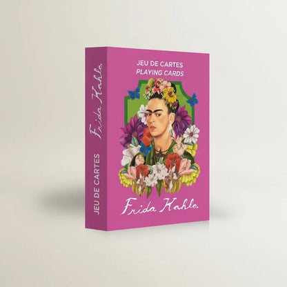 Eine geschlossene, hochkant stehende Produktbox des Frida Kahlo Kartenspiels von Mon Petit Art. Die Box ist in kräftigem Magenta gehalten. Auf der Vorderseite ist ein illustriertes Porträt von Frida Kahlo zu sehen, umrahmt von einem grünen Bogen, üppigen bunten Blumen und Schmetterlingen. Oben steht der Text „JEU DE CARTES / PLAYING CARDS“ und unten der geschwungene Schriftzug „Frida Kahlo“.
