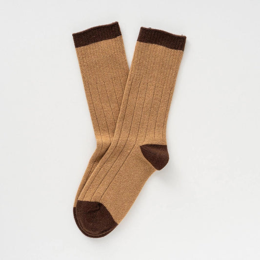 Ein Paar beigefarbene KLUE Merinowolle-Socken mit dunkelbraunem Bund, Ferse und Spitze im Rippstrick-Design.