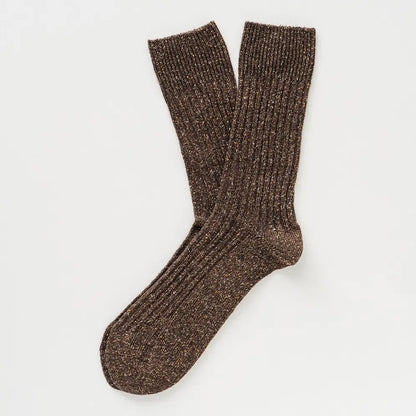 Flach liegende KLUE DUST STAR Design-Socken in Braun die die feine, hochwertige Strick-Struktur des Seiden-Woll-Gemischs zeigen.