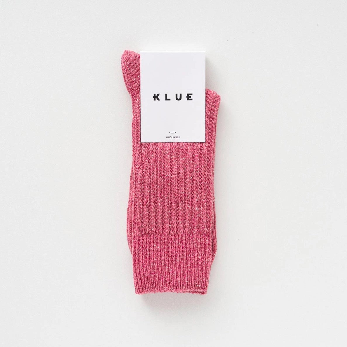 Flach liegende KLUE DUST STAR Design-Socken in Pink die die feine, hochwertige Strick-Struktur des Seiden-Woll-Gemischs zeigen.
