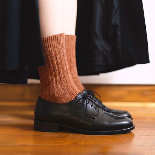 Nahaufnahme der getragenen KLUE DUST STAR Socken in Orange aus Seide und Wolle, kombiniert mit einem stylischen Halbschuh.