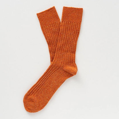 Flach liegende KLUE DUST STAR Design-Socken in Orange die die feine, hochwertige Strick-Struktur des Seiden-Woll-Gemischs zeigen.