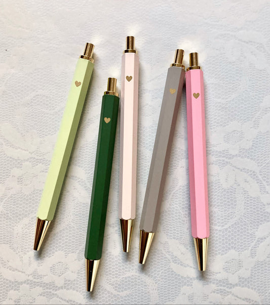 Vier minimalistische Kugelschreiber in den Pastellfarben Rosa, Flieder, Mintgrün und Blau auf hellem Untergrund.