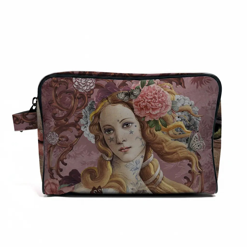Kulturbeutel von voglio bene mit einem kunstvollen Aufdruck der Venus von Botticelli, verziert mit Sternen-Tattoos im Gesicht, umgeben von rosa Pfingstrosen, Schmetterlingen und barocken Ornamenten auf altrosa Hintergrund. Seitlich ist eine Trageschlaufe sichtbar.