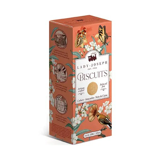Verpackung für Lady Joseph Cashew-Biscuits mit Blumen, Schmetterlingen und einem Vogel auf orangefarbenem Hintergrund.