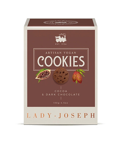 Frontale Produktansicht der Keksverpackung von „Lady Joseph“. Auf dem braunen Feld steht in weißer Schrift „ARTISAN VEGAN COOKIES“ sowie „COCOA & DARK CHOCOLATE 130g“. In der Mitte befinden sich Illustrationen einer geöffneten Kakaobohne, eines Schoko-Cookies und einer Kakaofrucht. Am unteren cremefarbenen Rand prangt der Markenname „LADY JOSEPH“.