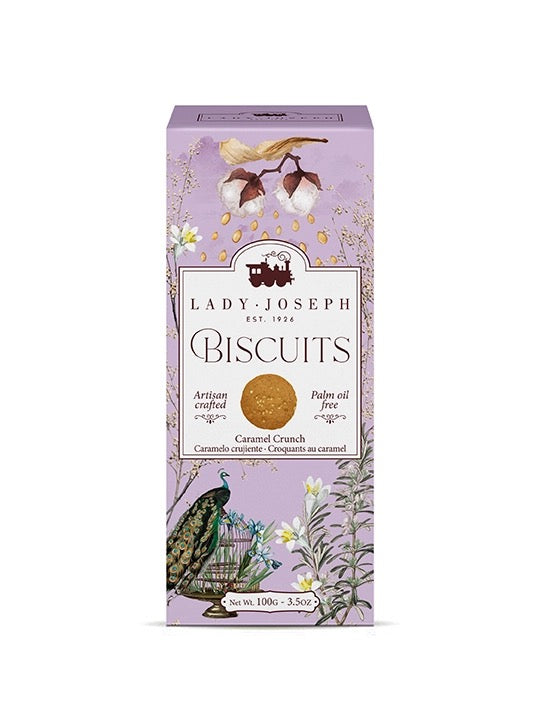 Hellviolette Verpackung mit floralen Illustrationen, einem Pfau und der Aufschrift 'Lady Joseph Biscuits Caramel Crunch'.