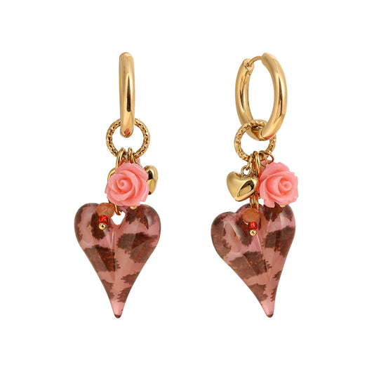 Goldene Kreolen-Ohrringe mit rosafarbenen Herz-Anhängern im Leo-Muster, kleinen Perlen, goldenen Herzchen und rosa Rosen-Details vor grauem Hintergrund.