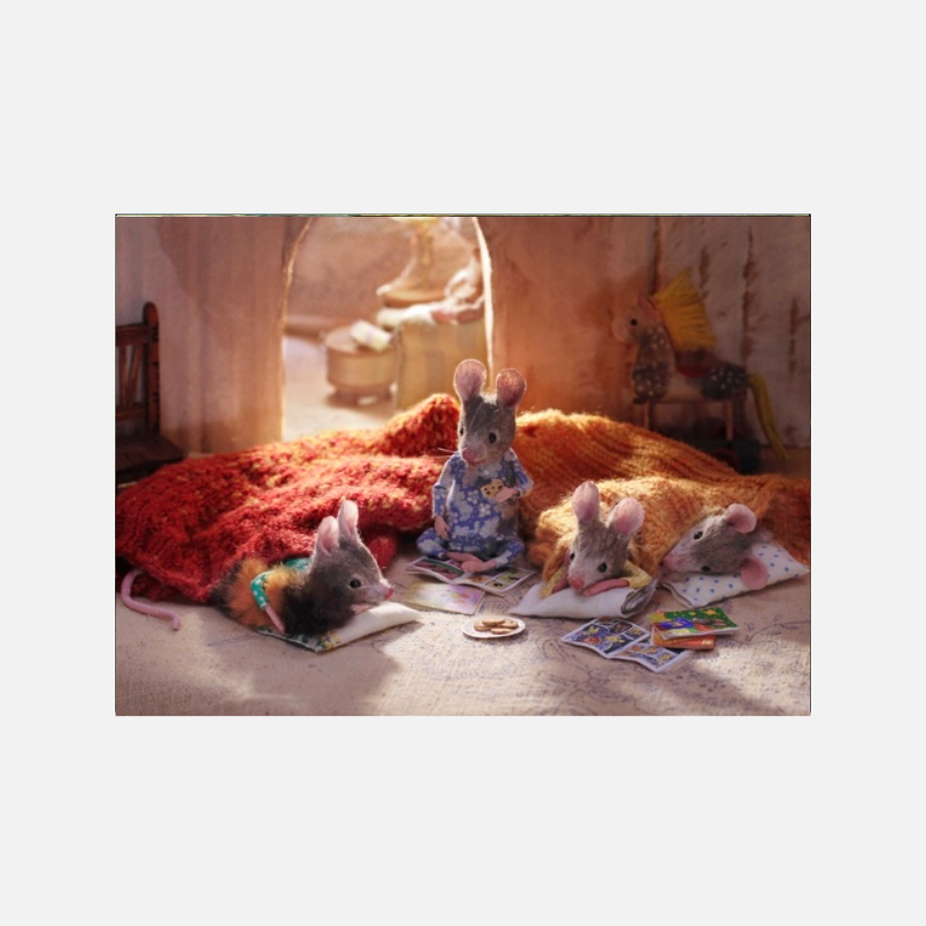 Eine gemütliche Miniatur-Szene mit vier kleinen Mäusefiguren im Bett. Die vermenschlichten Mäuse tragen Pyjamas, liegen auf Kissen unter bunten, gestrickten Decken und lesen winzige Bücher. Auf dem Boden liegen kleine Kekse, und im Hintergrund ist ein Spielzeug-Schaukelpferd zu sehen.