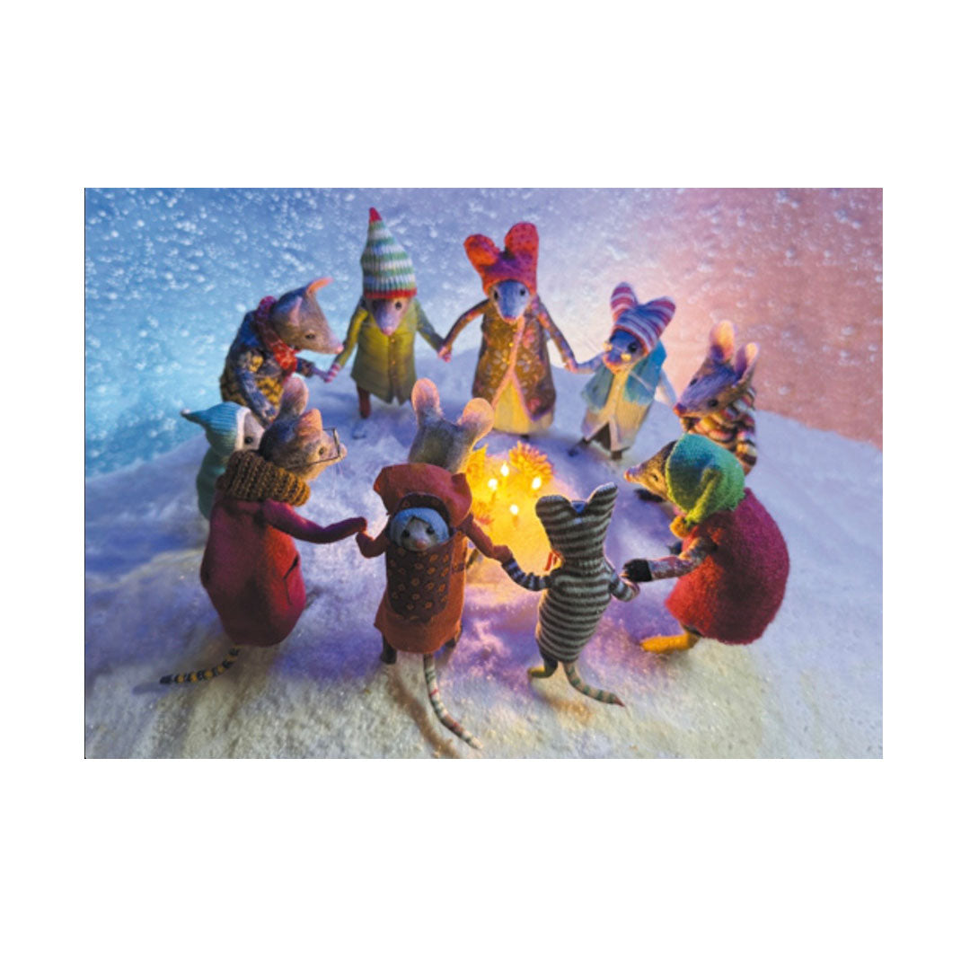 Eine friedliche Winterszene im Schnee, in der eine Gruppe von zehn niedlichen, gefilzten Mäusen einen Kreis bildet und sich an den Händen hält. Die Mäuse tragen bunte Winterkleidung, Mützen und Schals. In der Mitte des Kreises leuchten kleine Kerzen warm im Schnee.