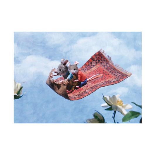 Zwei Mäusefiguren sitzen auf einem fliegenden Teppich über Blumen vor blauem Himmel
