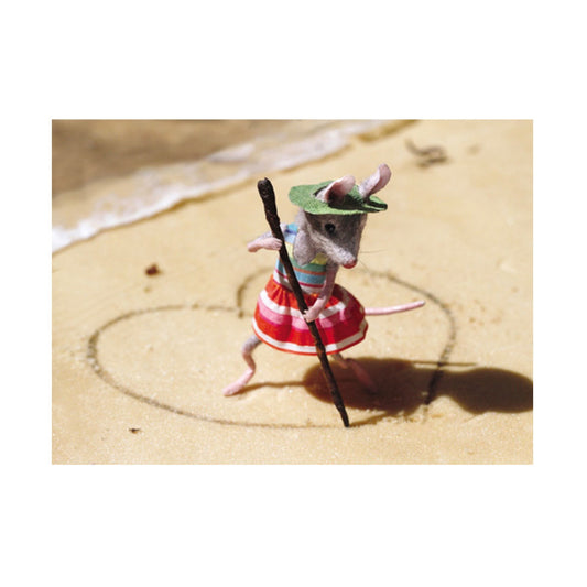 Mausfigur mit grünem Hut, gestreiftem Oberteil und rotem Rock hält einen Stock und steht auf Sand und malt ein Herz 
