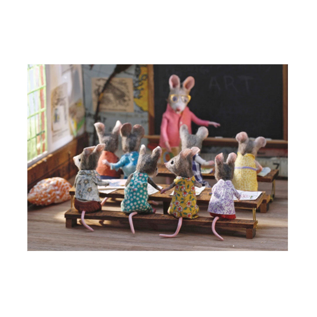 Mäuse in einem Klassenzimmer auf einer  Sitzbank. Eine Maus steht vor einer Tafel.