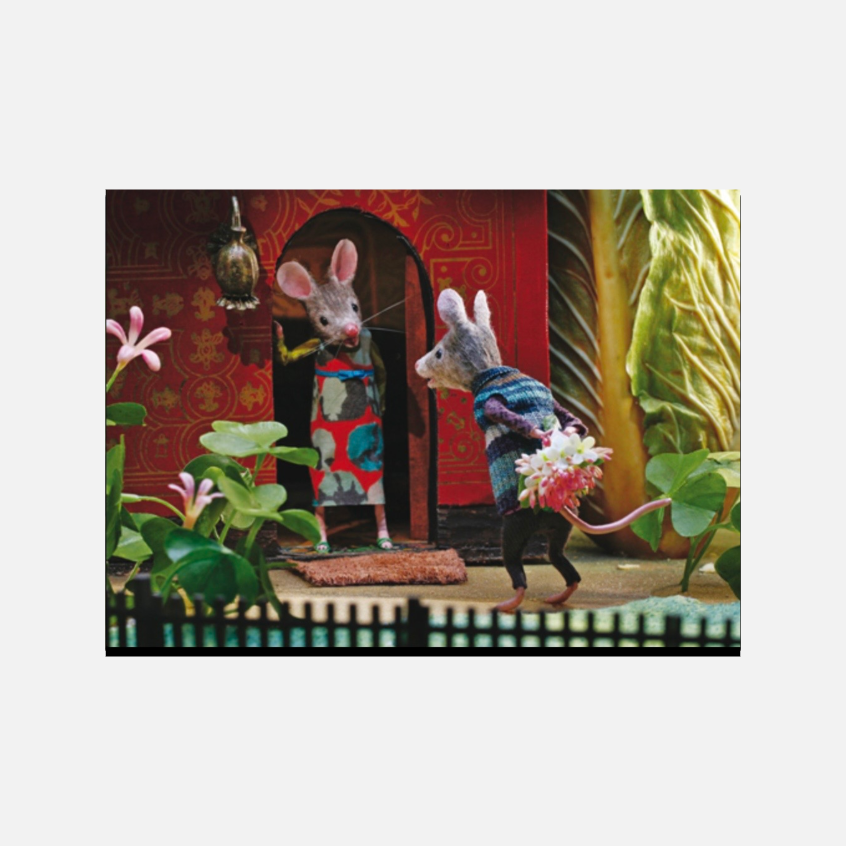 Eine Maus mit Blumenstrauß hinter dem Rücken überrascht eine andere Maus an einer roten Haustür.