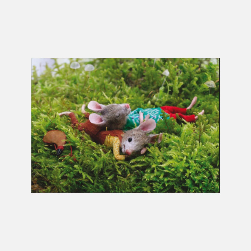 Zwei Mäuse liegen entspannt im grünen Moos und schauen in den Himmel, umgeben von kleinen Pilzen.