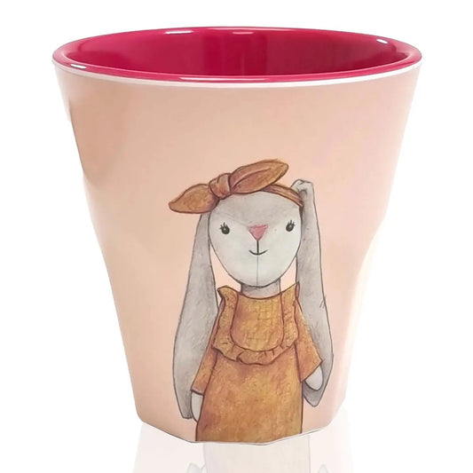 Becher mit rosa Innenfläche und Illustration eines Hasen mit Schleife und Kleid auf der Außenseite.