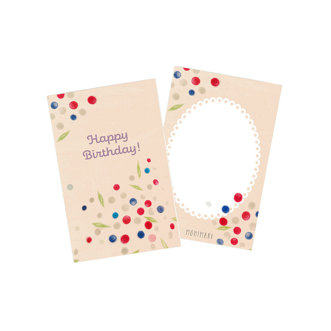 Minikarte von Monimari zum Geburtstag in Beigetönen. Vorderseite: Buntes Konfetti in Rot, Blau und Silber mit kleinen grünen Blättern und dem Schriftzug „Happy Birthday!“. Rückseite: Beige Karte mit weißem, geperltem Oval-Rahmen, umrahmt von buntem Konfetti.