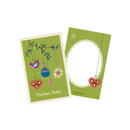 Minikarte von Monimari zu Weihnachten in Olivgrün. Vorderseite: Nadelzweig mit hängendem Weihnachtsschmuck, einem Vogel und Lebkuchenherz sowie der Schriftzug „Frohes Fest!“. Rückseite: Grüner Hintergrund mit weißem, geperltem Oval-Rahmen und einem kleinen Lebkuchenherz unten rechts.