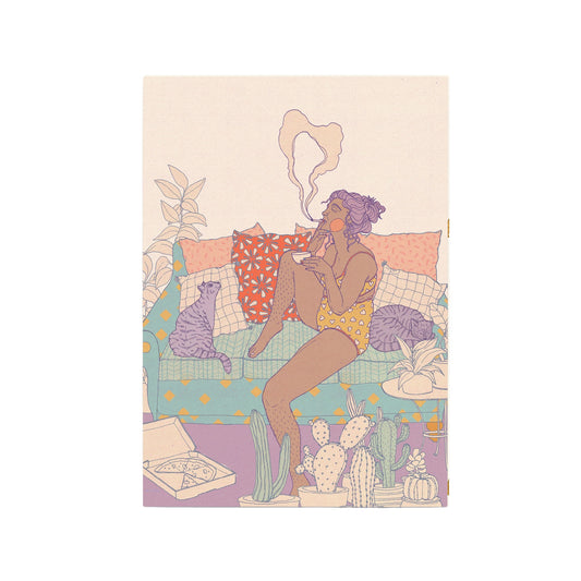 Eine illustrierte Postkarte zeigt eine Person mit lilafarbenen Haaren, die entspannt auf einer türkis gemusterten Couch sitzt. Sie trägt ein gelbes Set aus BH und Slip mit Herzmuster und raucht. Ihre Beine sind angewinkelt, und sie hält eine Tasse. Zwei Katzen, eine gestreifte und eine lila, kuscheln sich zu ihr. Auf dem lila Teppich davor steht eine offene Pizzaschachtel mit einer Scheibe Pizza, umgeben von verschiedenen Kakteen und Sukkulenten in Töpfen. 