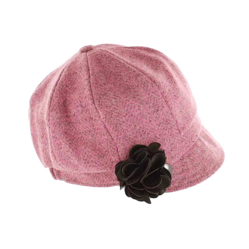 Rosa Stoffmütze mit schwarzer Stoffblume als Verzierung an der Seite.